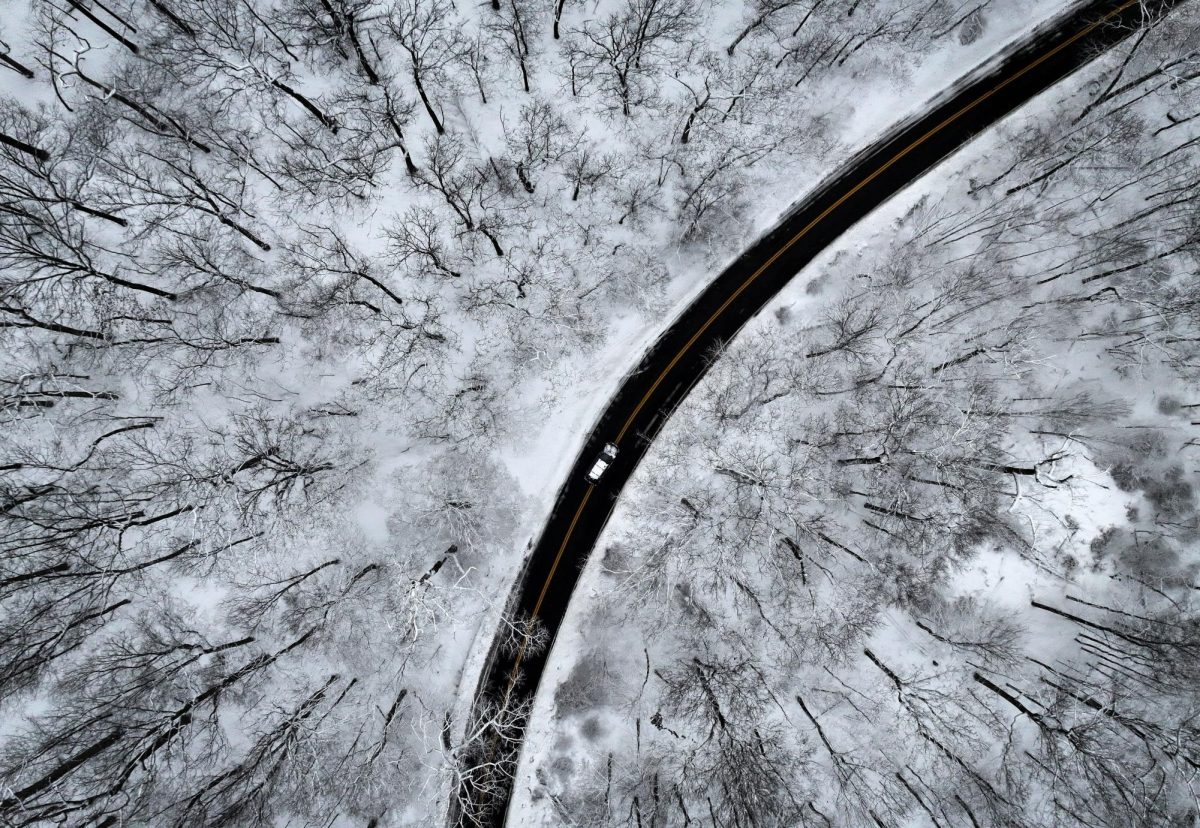 A drone view of a car driving through the snow covered woods of Blauvelt State Park after a winter storm bore down on the U.S. Northeast in Orangetown, New York, U.S., December 27, 2025. REUTERS/Mike Segar